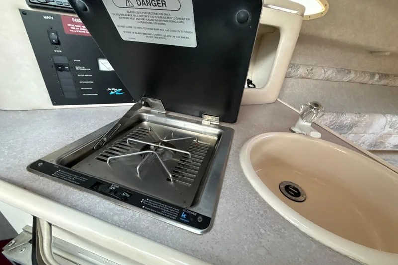 Slide: The Image of 1996 Sea Ray 240 Sundancer interior with stove and sink in cabin. - 50