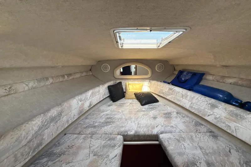 Slide: The Image of Interior cabin of 1996 Sea Ray 240 Sundancer with cushions and porthole. - 51