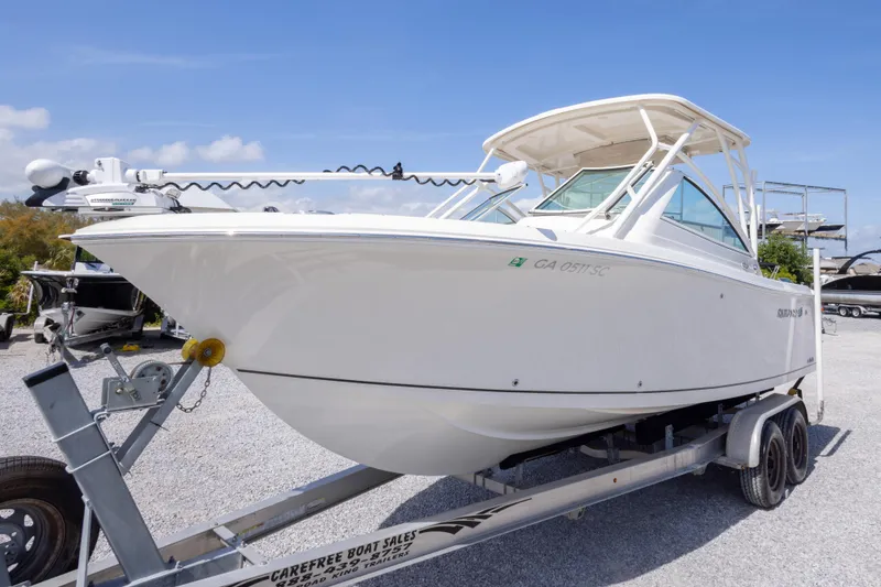 Slide: The Image of 2018 Sailfish 245 DC boat on trailer under clear blue sky. - 10