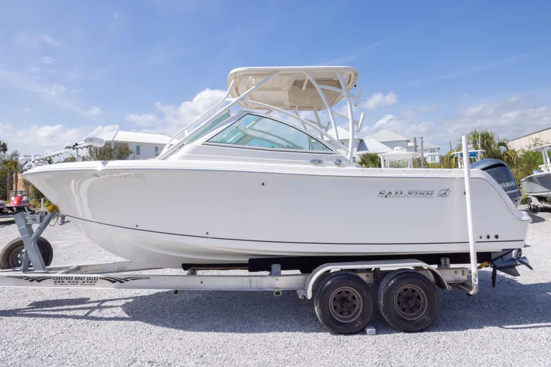 Slide: The Image of 2018 Sailfish 245 DC boat on trailer, side view, under clear blue sky. - 11