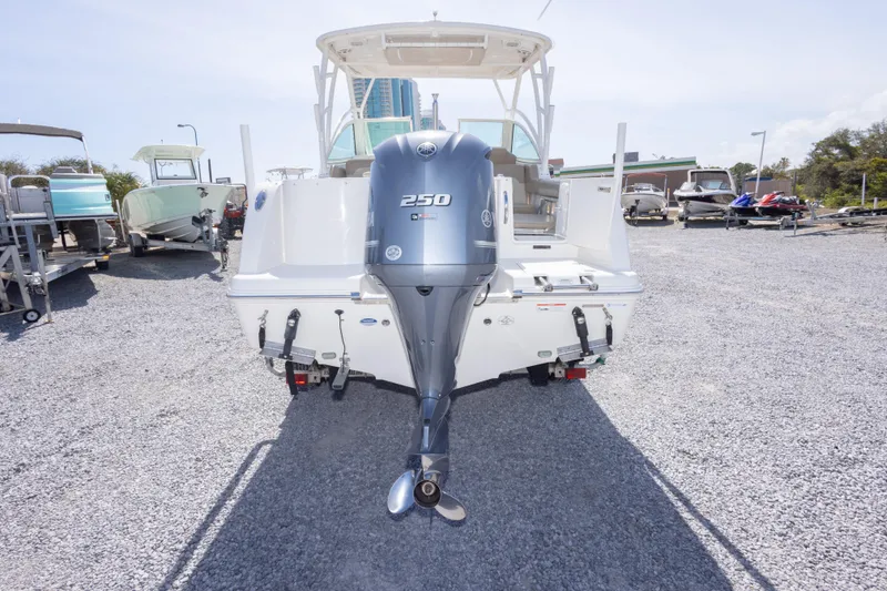 Slide: The Image of 2018 Sailfish 245 DC boat with Yamaha 250 outboard motor, parked on gravel. - 14