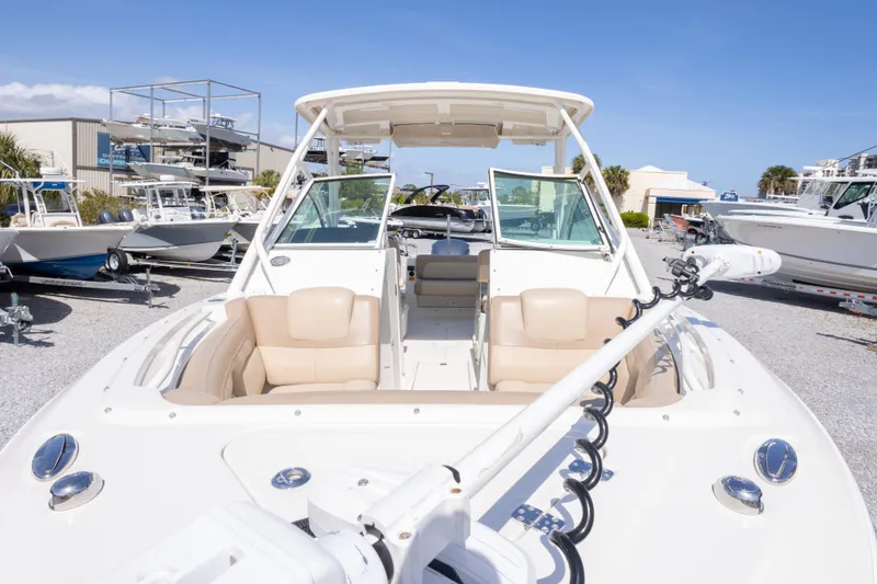 Slide: The Image of 2018 Sailfish 245 DC boat with open deck, beige seating, and clear skies in the background. - 16