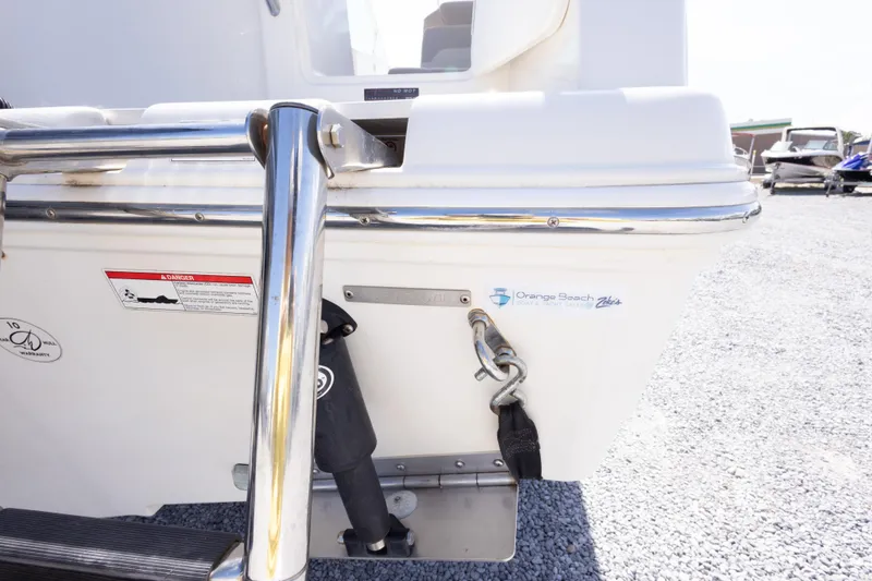 Slide: The Image of 2018 Sailfish 245 DC boat stern with safety warnings and Orange Beach logo. - 17