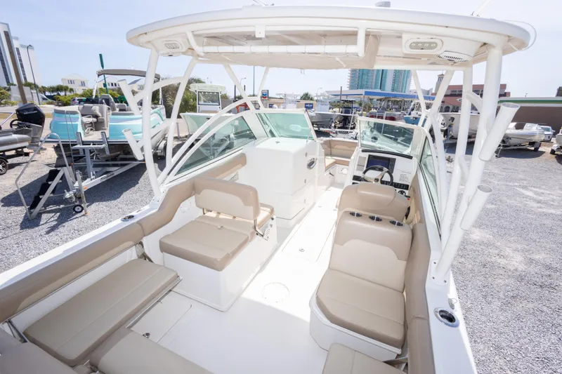 Slide: The Image of 2018 Sailfish 245 DC boat interior with beige seating and modern dashboard. - 18