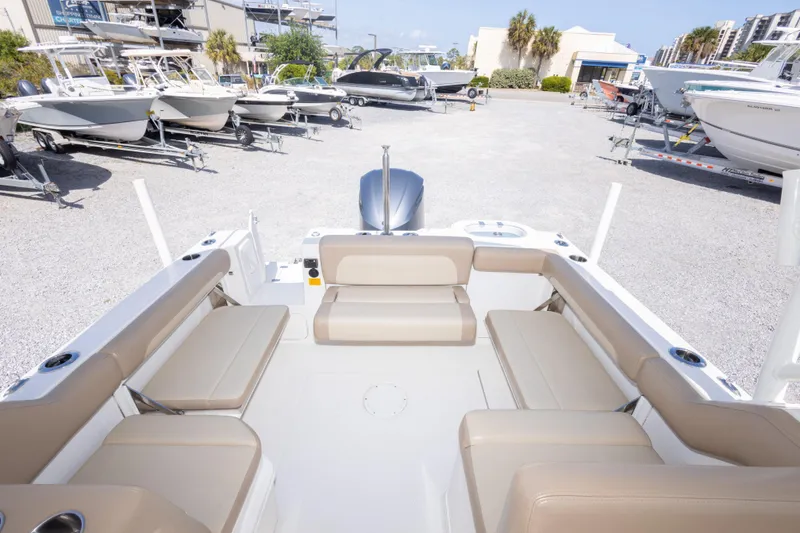 Slide: The Image of 2018 Sailfish 245 DC boat interior with beige seating, parked in a marina. - 20