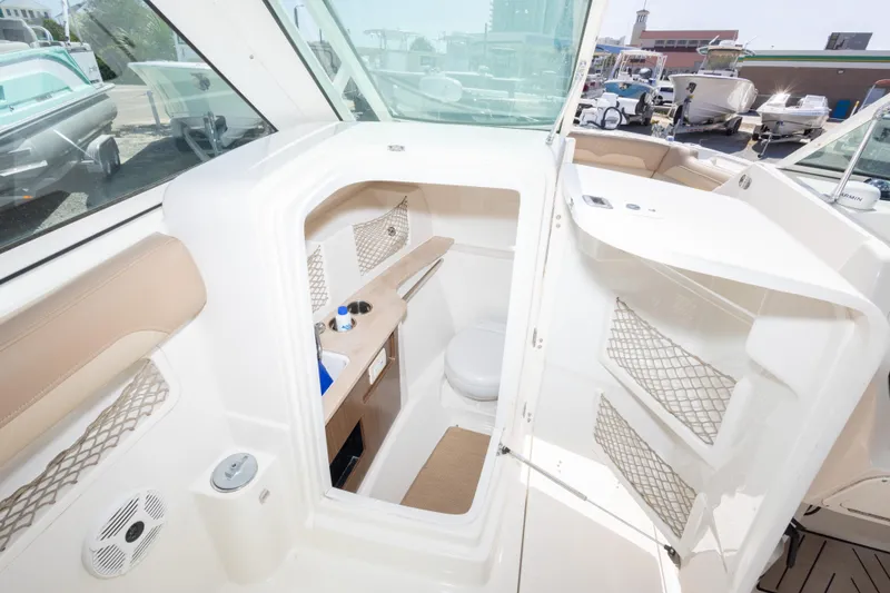 Slide: The Image of 2018 Sailfish 245 DC boat interior with open cabin door and visible amenities. - 23