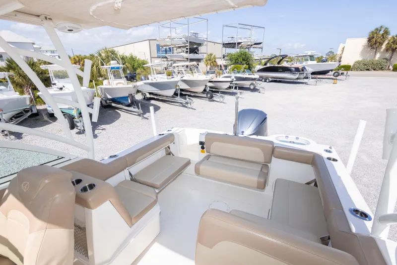Slide: The Image of 2018 Sailfish 245 DC boat interior with beige seating, parked among other boats. - 25