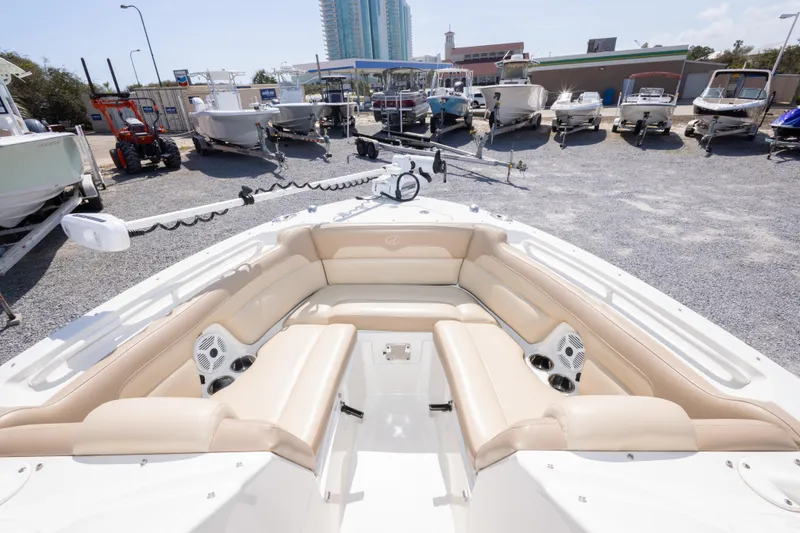 Slide: The Image of 2018 Sailfish 245 DC boat with beige seating, displayed in a marina with other boats. - 28