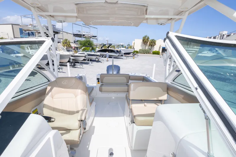 Slide: The Image of 2018 Sailfish 245 DC boat interior with beige seating, open deck, and clear windshield. - 31