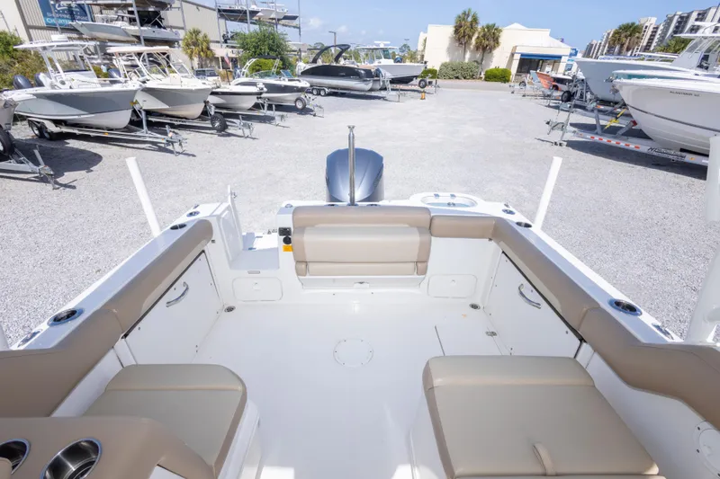 Slide: The Image of 2018 Sailfish 245 DC boat interior with beige seating, parked among other boats. - 34