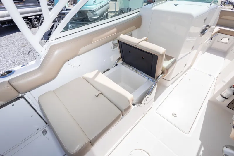 Slide: The Image of 2018 Sailfish 245 DC boat interior with beige seating and storage compartment. - 36