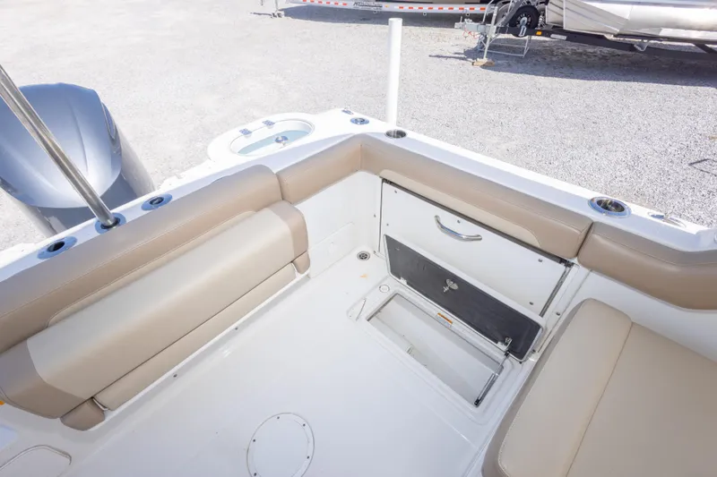 Slide: The Image of 2018 Sailfish 245 DC boat interior with beige seating and storage compartments. - 37