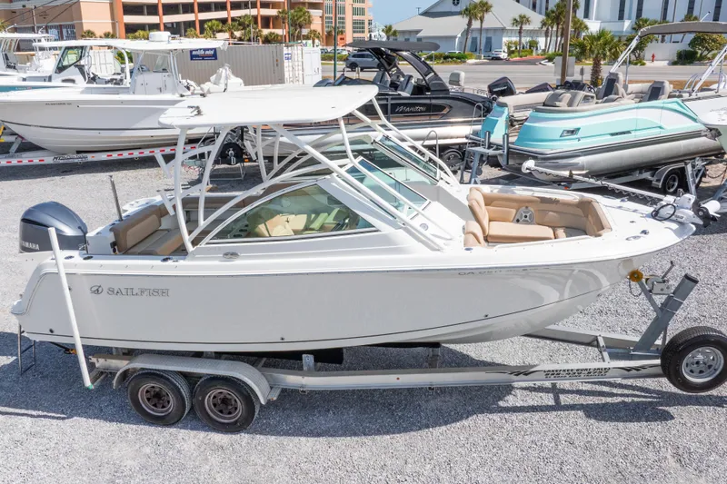 Slide: The Image of 2018 Sailfish 245 DC boat on trailer, parked in marina with other boats. - 5