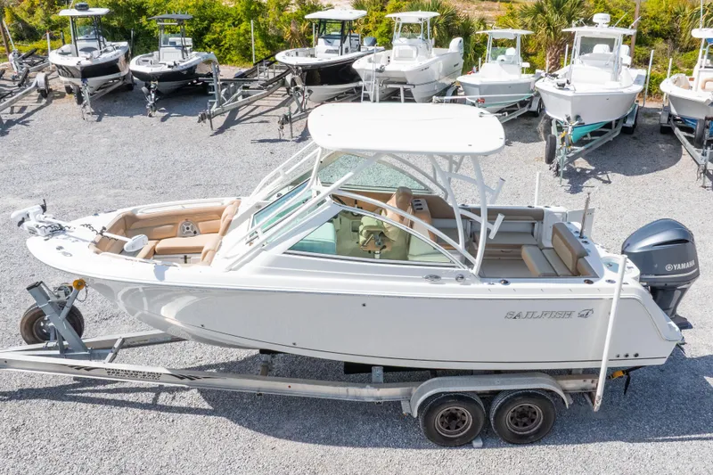 Slide: The Image of 2018 Sailfish 245 DC boat on trailer, surrounded by other boats in a lot. - 6