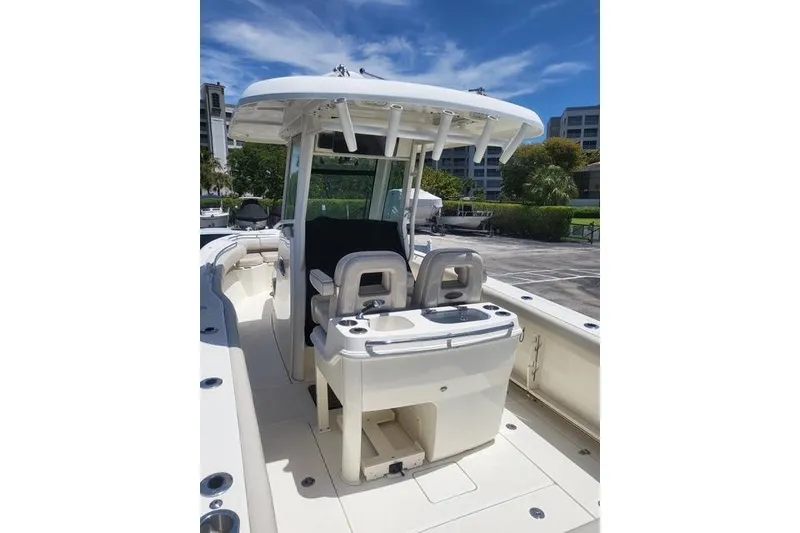 Slide: The Image of 2018 Boston Whaler 280 Outrage boat with center console and seating, docked under clear skies. - 5