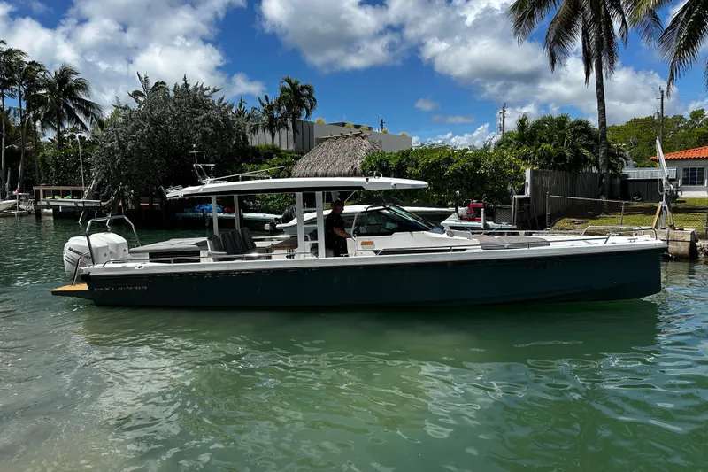Slide: The Image of 2018 Axopar 37 Sun-Top boat docked in a tropical waterfront setting. - 10