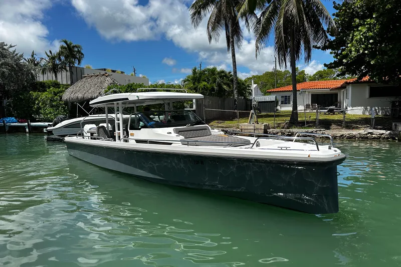 Slide: The Image of 2018 Axopar 37 Sun-Top boat docked in a tropical waterfront setting. - 12