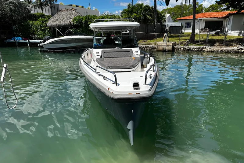 Slide: The Image of 2018 Axopar 37 Sun-Top boat docked in a serene waterfront setting. - 14