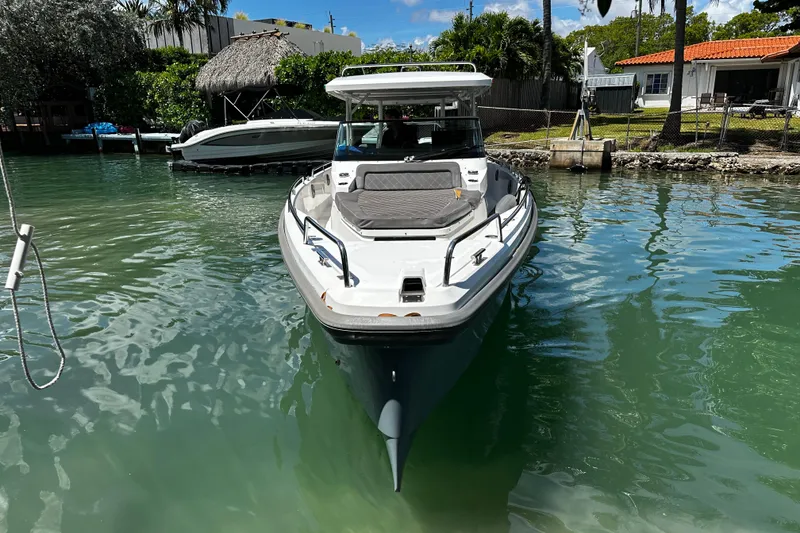 Slide: The Image of 2018 Axopar 37 Sun-Top boat docked in a serene waterfront setting. - 15