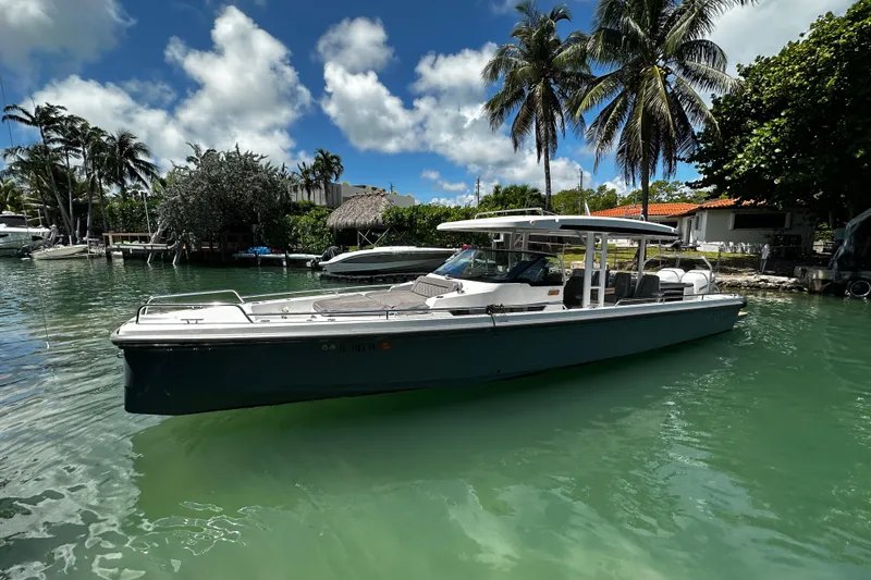 Slide: The Image of 2018 Axopar 37 Sun-Top boat on tropical water, surrounded by palm trees. - 16