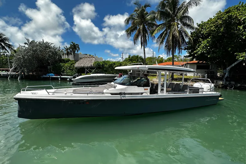 Slide: The Image of 2018 Axopar 37 Sun-Top boat docked in tropical marina with palm trees. - 17