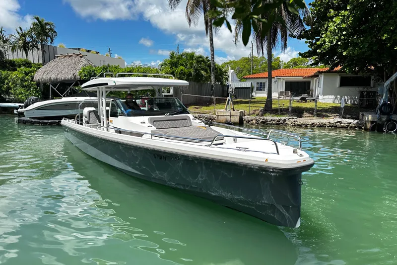 Slide: The Image of 2018 Axopar 37 Sun-Top boat docked in a tropical canal setting. - 18