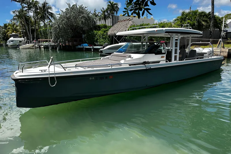 Slide: The Image of 2018 Axopar 37 Sun-Top boat docked in a tropical marina setting. - 19