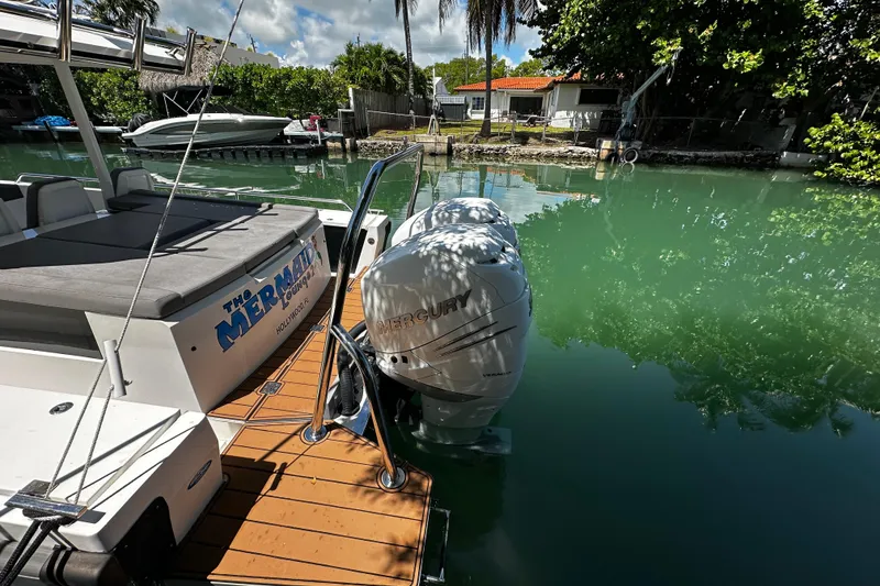Slide: The Image of 2018 Axopar 37 Sun-Top boat docked with twin Mercury engines in a serene canal setting. - 21