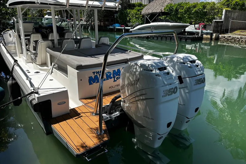 Slide: The Image of 2018 Axopar 37 Sun-Top boat with twin Mercury 350 engines docked in a serene canal. - 22