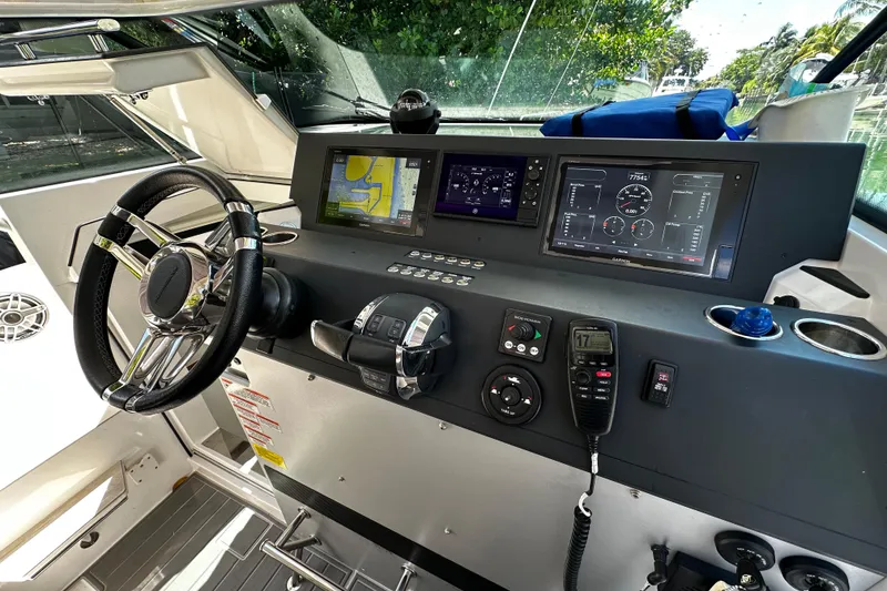 Slide: The Image of 2018 Axopar 37 Sun-Top helm with steering wheel, navigation screens, and control panel. - 29