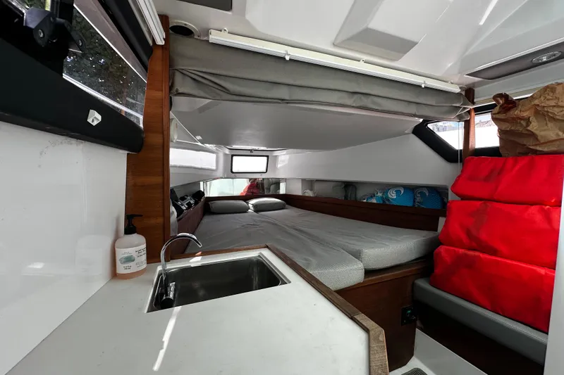 Slide: The Image of Interior cabin of 2018 Axopar 37 Sun-Top with bed, sink, and red cushions. - 36