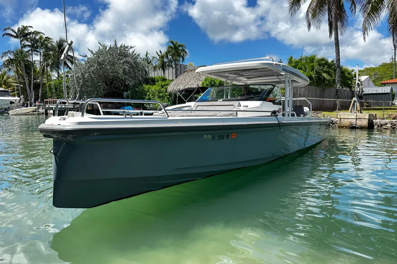 Slide: The Image of 2018 Axopar 37 Sun-Top boat docked in tropical waters with palm trees. - 4