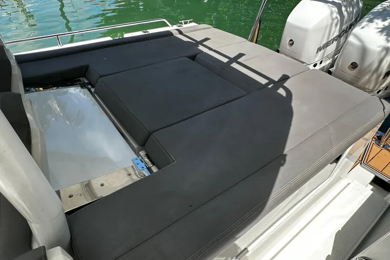 Slide: The Image of 2018 Axopar 37 Sun-Top boat with cushioned seating and dual Mercury outboard engines. - 44