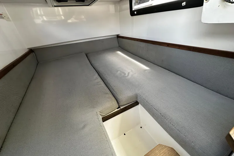 Slide: The Image of Interior cabin of 2018 Axopar 37 Sun-Top with gray cushions and wooden accents. - 45