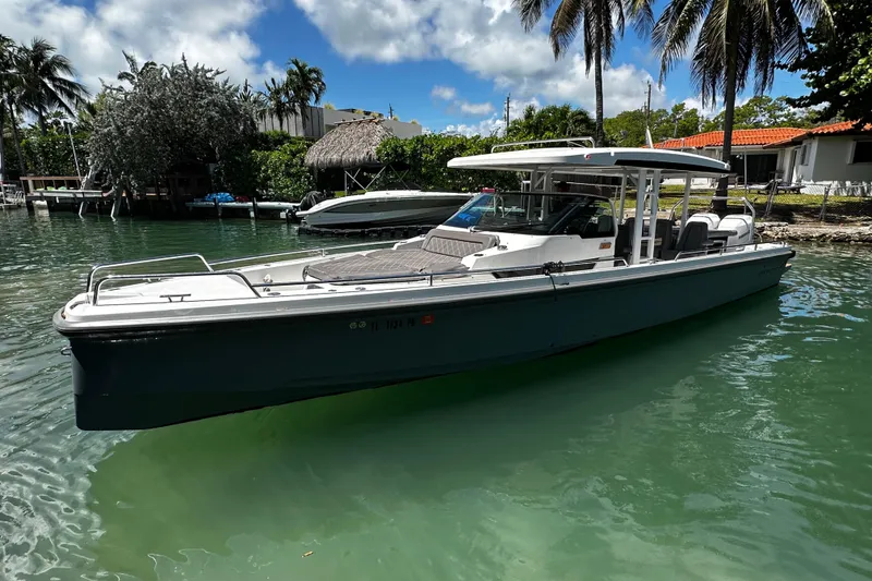 Slide: The Image of 2018 Axopar 37 Sun-Top boat docked in a tropical waterfront setting. - 5