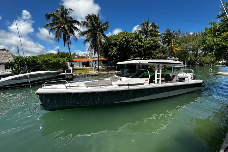 Slide: The Image of 2018 Axopar 37 Sun-Top boat docked in tropical marina with palm trees. - 6