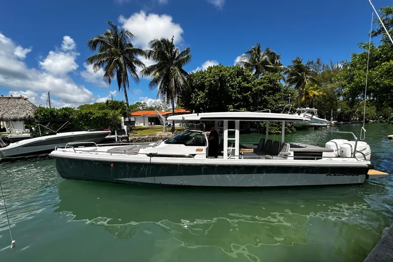Slide: The Image of 2018 Axopar 37 Sun-Top boat docked in tropical marina with palm trees. - 7