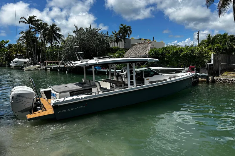 Slide: The Image of 2018 Axopar 37 Sun-Top boat docked in a tropical marina setting. - 8