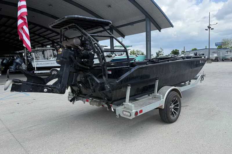 Slide: The Image of 2024 Prodigy 17 boat on trailer, parked under a metal canopy with American flag. - 3