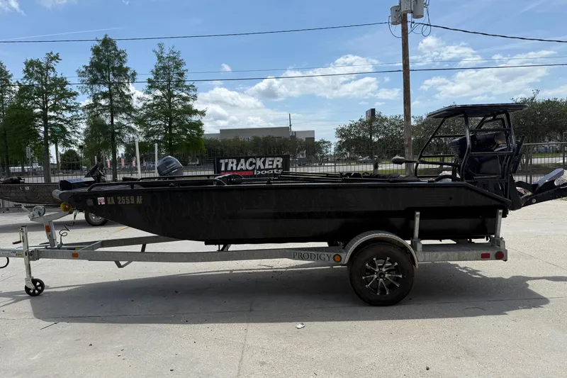 Slide: The Image of 2024 Prodigy 17 boat on trailer, parked outdoors under a clear sky. - 6