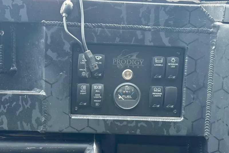 Slide: The Image of Control panel of a 2024 Prodigy 17 boat with various switches and fuel gauge. - 9