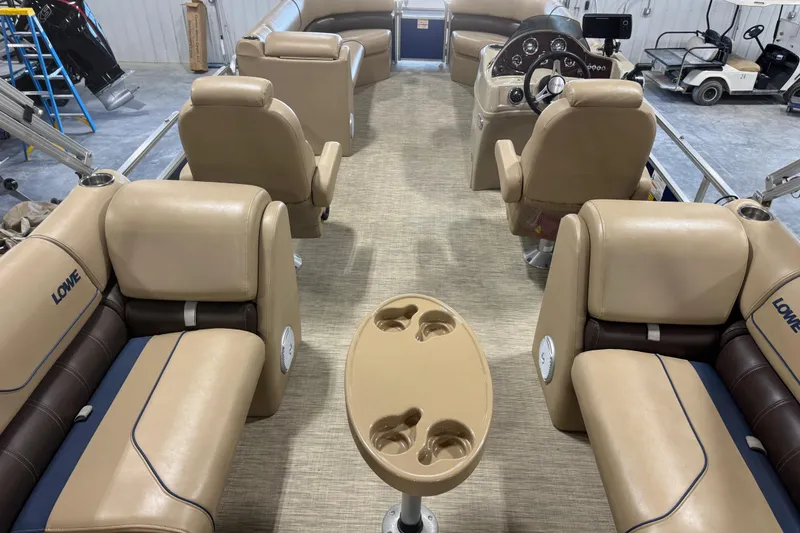 Slide: The Image of 2017 Lowe SS 250 pontoon boat interior with tan seating and steering console. - 8