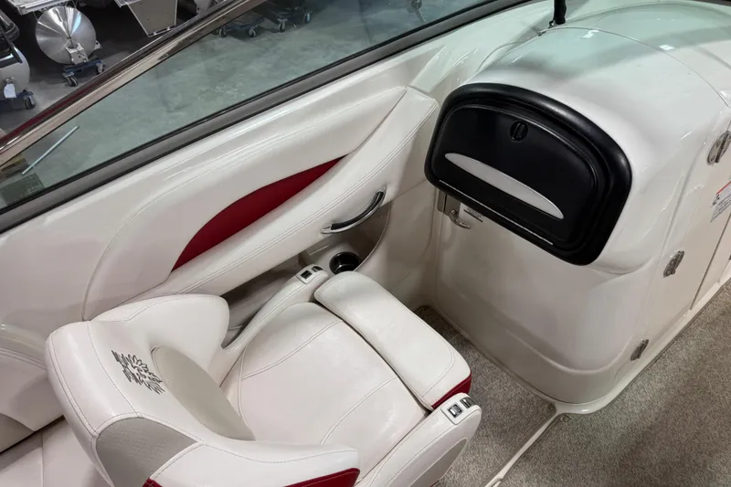 Slide: The Image of 2010 Chaparral 256 SSX boat interior with white seating and storage compartment. - 9