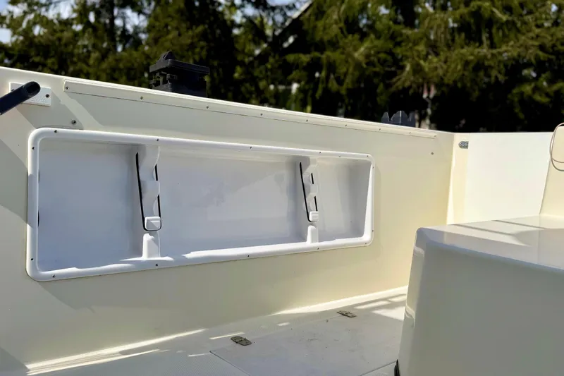 Slide: The Image of 2006 Osprey Legend boat interior with storage compartment, surrounded by lush greenery. - 11