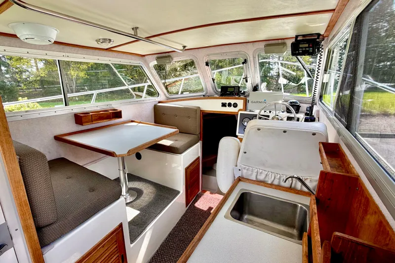 Slide: The Image of Interior of a 2006 Osprey Legend boat with seating, table, and navigation equipment. - 13