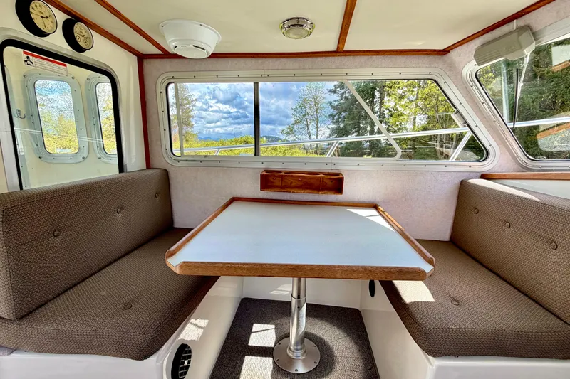 Slide: The Image of Cozy interior of a 2006 Osprey Legend boat with a dining area and scenic windows. - 15