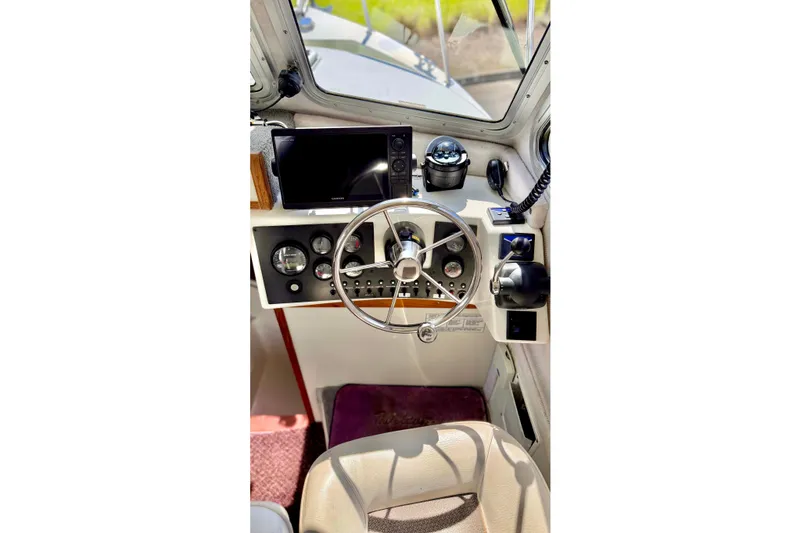 Slide: The Image of Interior view of a 2006 Osprey Legend boat cockpit with steering wheel and navigation equipment. - 16