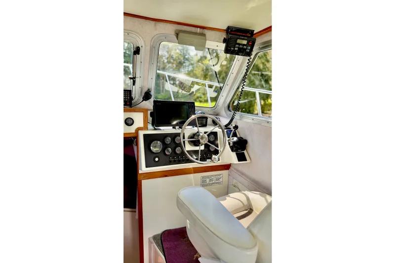 Slide: The Image of Interior of a 2006 Osprey Legend boat cockpit with steering wheel and navigation equipment. - 17