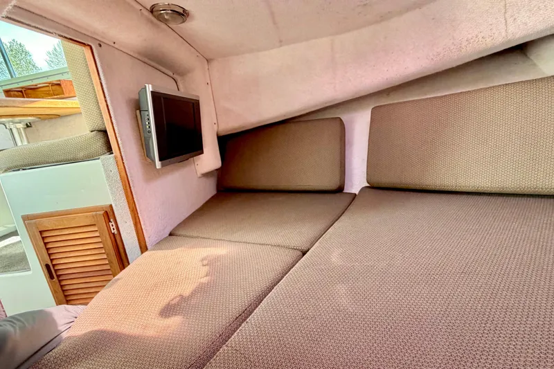 Slide: The Image of Interior cabin of a 2006 Osprey Legend boat with cushioned seating and a mounted TV. - 18