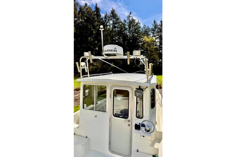 Slide: The Image of 2006 Osprey Legend boat with Garmin radar, surrounded by trees and blue sky. - 21